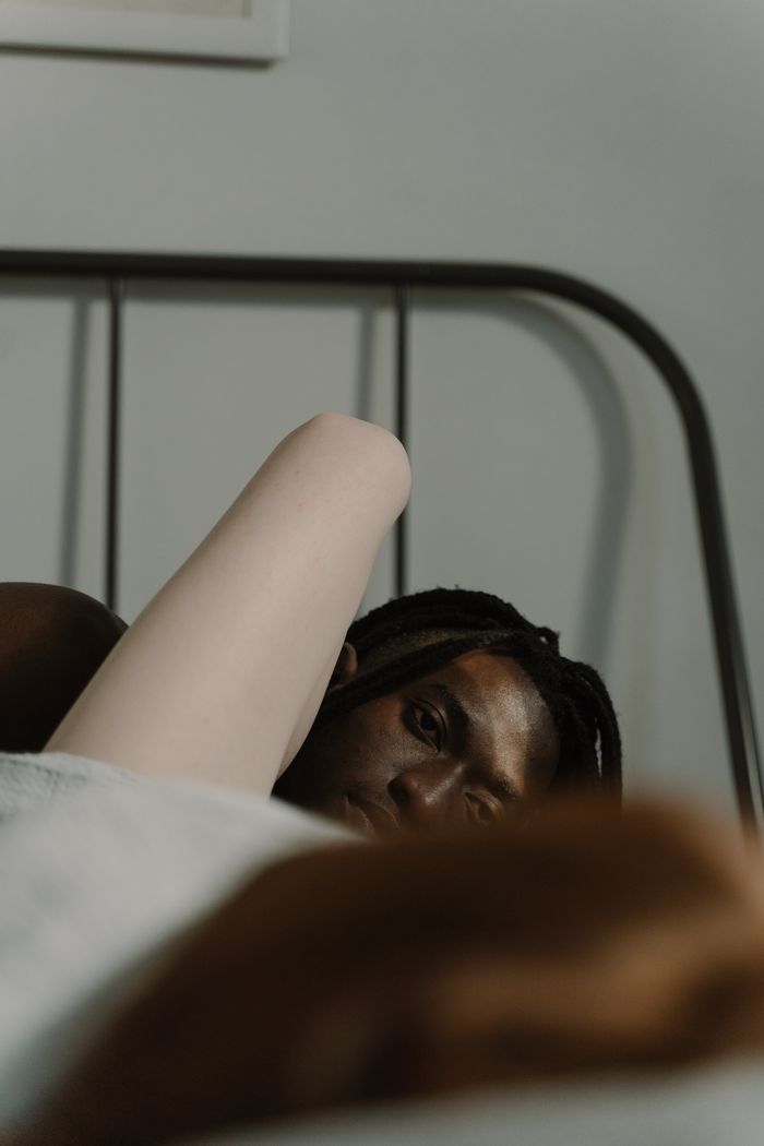 A close-up of an intimate couple in a cozy bedroom setting, emphasizing love and togetherness.